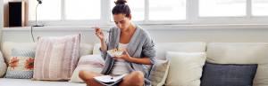 Girl-eats-couch-with-bowl-and-journal-in-lap