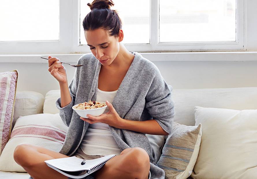 Girl-eats-couch-with-bowl-and-journal-in-lap