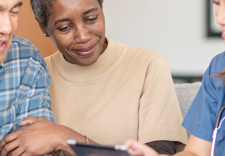 senior couple looks at longevity health care plan with doctor