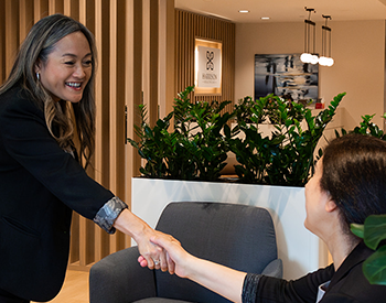 Corporate team member in business development welcoming a client at a private healthcare office