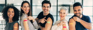 5 adults smile with vaccine bandaids