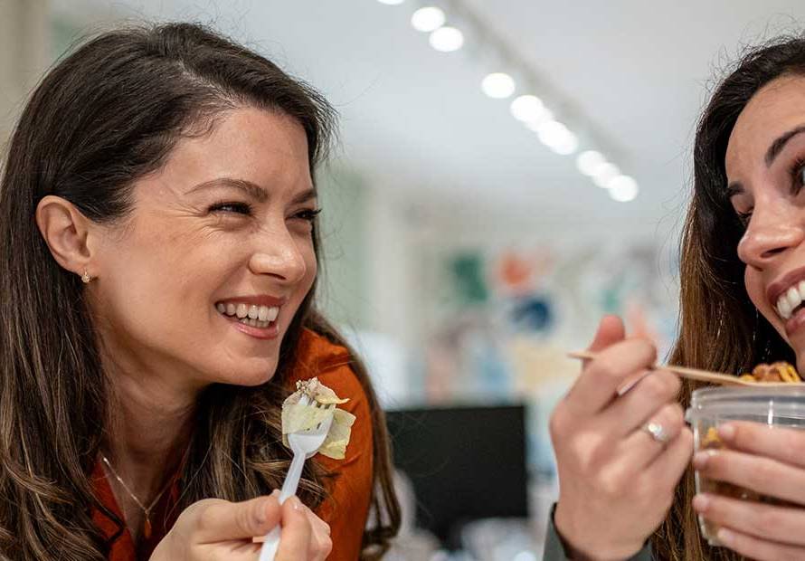 2-women-looking-at-eachother-smiling-eating