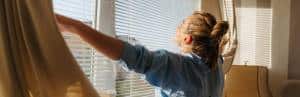 Redefining PCOS as PMOS: A Huge Win for Women’s Health 2 Woman opening blinds to sunshine