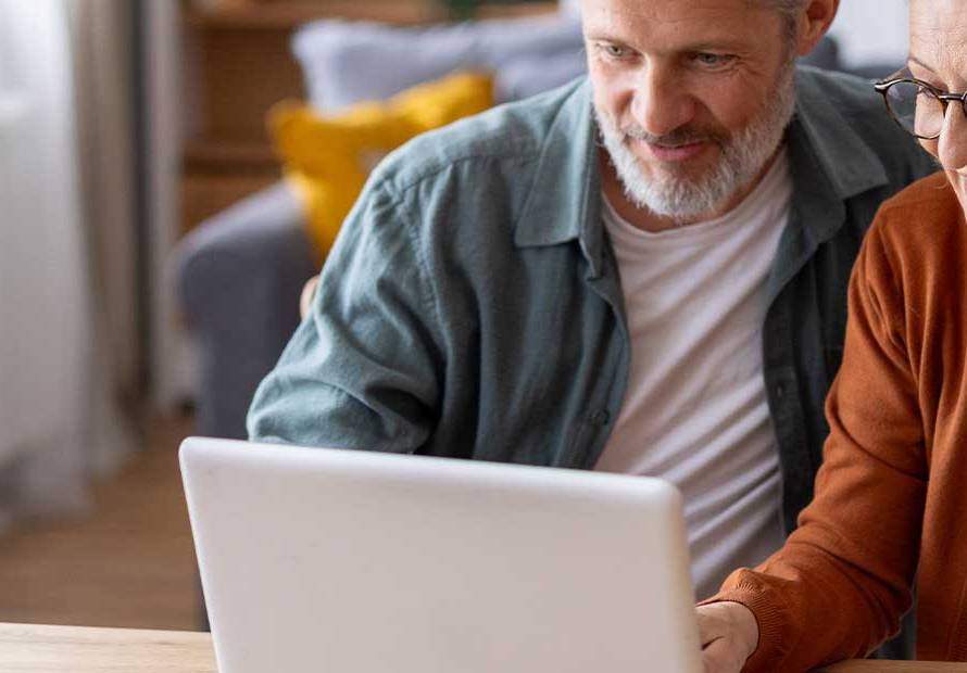 Older couple smiling at laptop